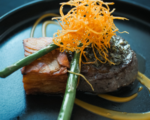 Trozo de carne y salmón decorado con espárragos